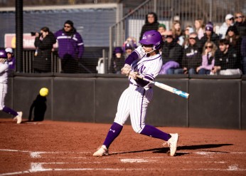 A Northwestern softball player hits a ball 
