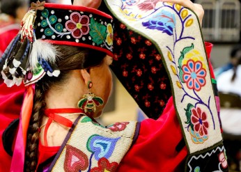 A woman wears traditional clothing during the 2022 spring pow wow 